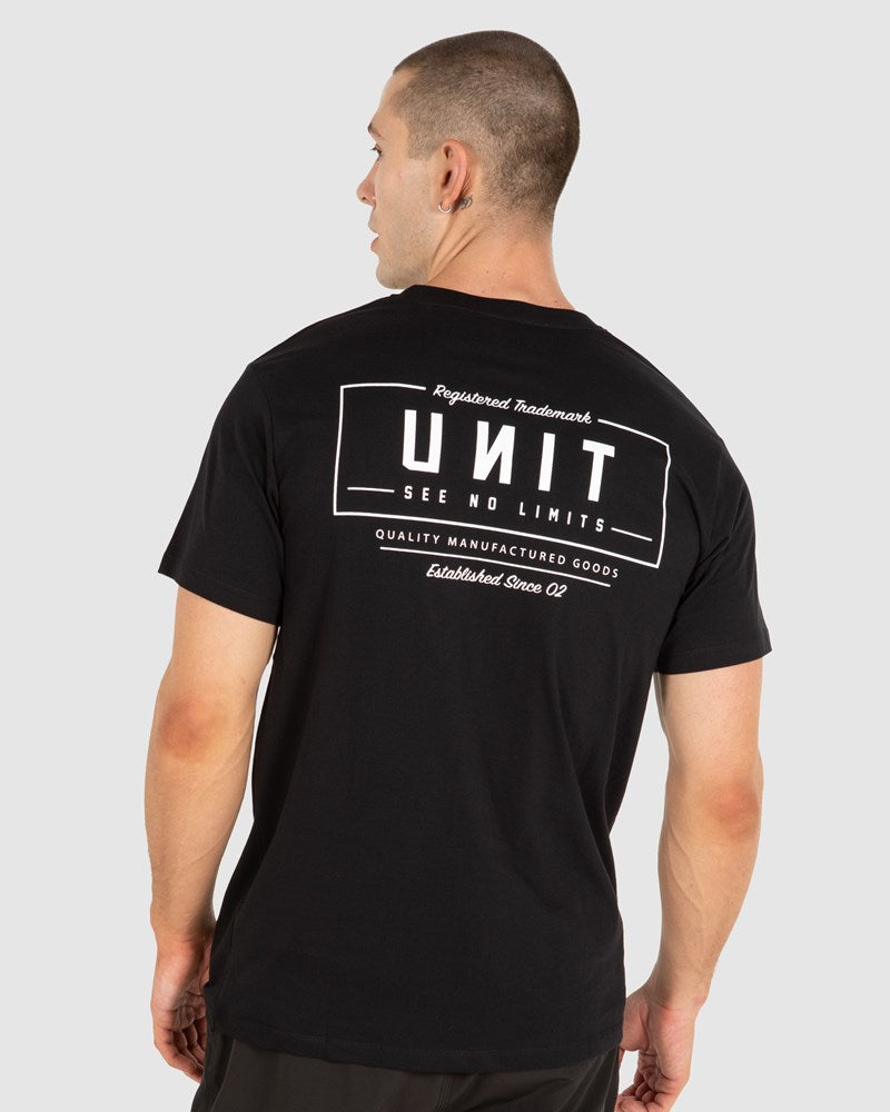 A man's back view wearing a black crew neck t-shirt with a large white text 'UNIT' and smaller text 'Quality Manufactured Goods' on the back.